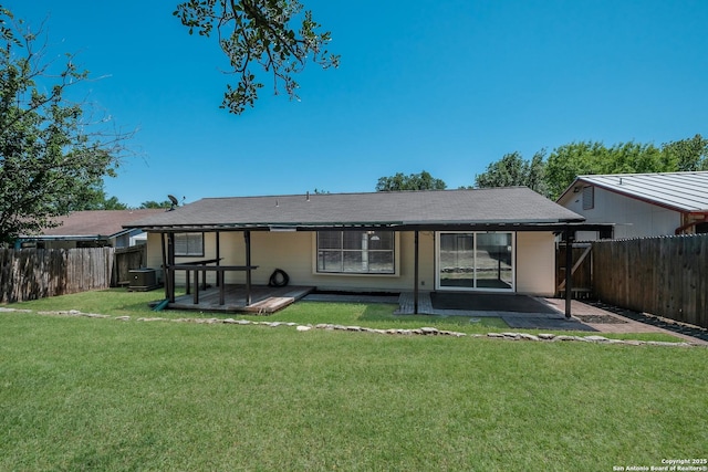 rear view of property featuring a fenced backyard, cooling unit, a yard, and a patio area