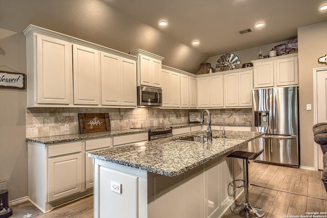 2097 Range Rd, Seguin, TX 78155 - kitchen with a sink, stainless steel appliances, light wood-type flooring, tasteful backsplash, and visible vents
