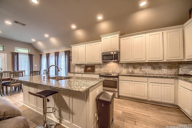 2097 Range Rd, Seguin, TX 78155 - kitchen featuring appliances with stainless steel finishes, tasteful backsplash, a kitchen island with sink, and a sink