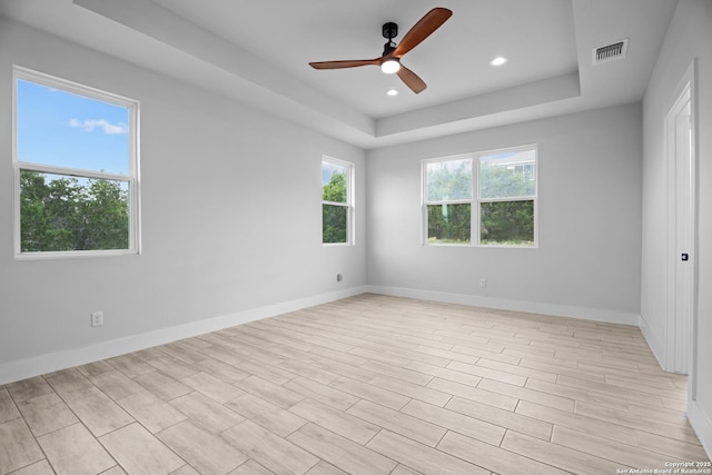 unfurnished room with recessed lighting, ceiling fan, baseboards, visible vents, and a tray ceiling