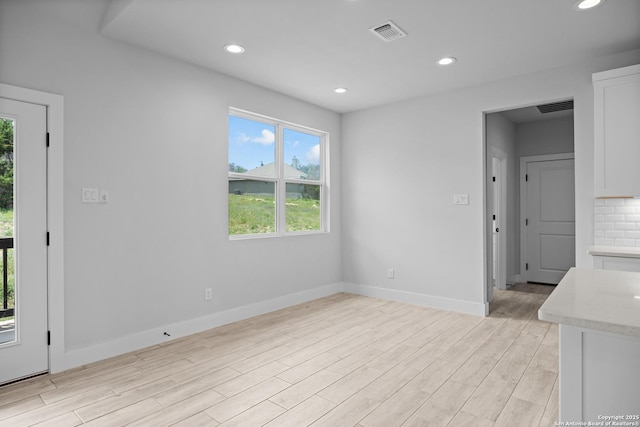 spare room featuring baseboards, visible vents, light wood-type flooring, and recessed lighting