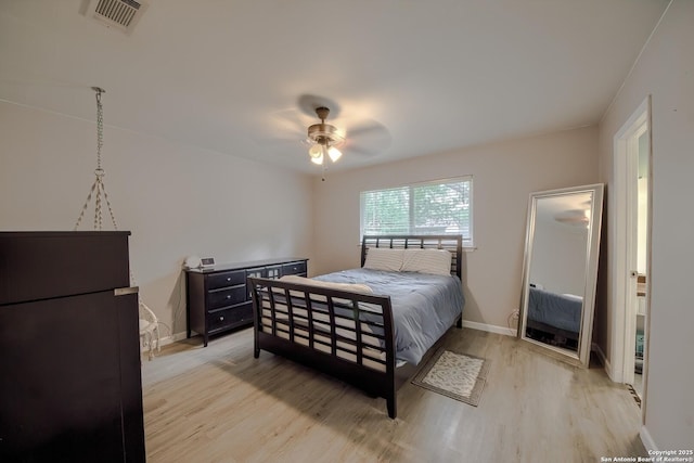 bedroom with baseboards, visible vents, ceiling fan, and light wood-style floors