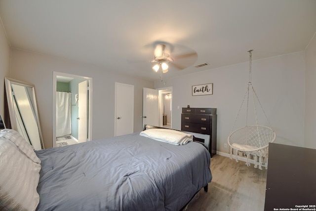 bedroom with baseboards, visible vents, light wood-type flooring, and ensuite bathroom