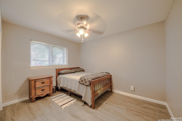 bedroom featuring a ceiling fan, baseboards, and light wood-type flooring