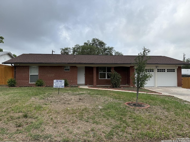 ranch-style home with concrete driveway, fence, a garage, and brick siding