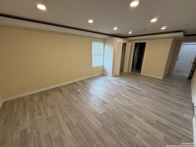 empty room featuring recessed lighting, light wood-style flooring, and baseboards