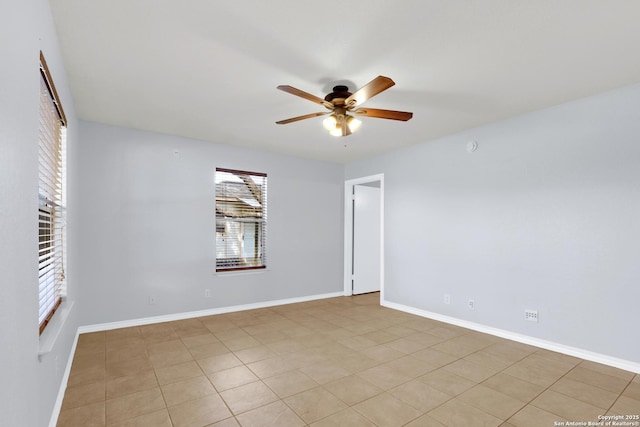 unfurnished room featuring a ceiling fan and baseboards