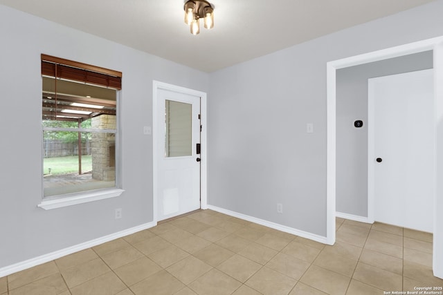 entrance foyer with light tile patterned floors and baseboards