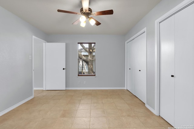 unfurnished bedroom with light tile patterned floors, a ceiling fan, and baseboards