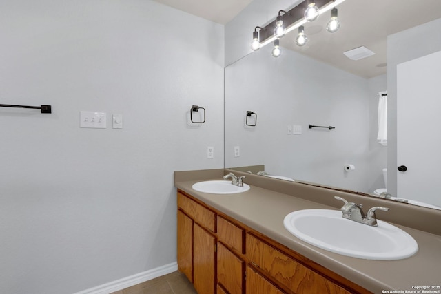 bathroom featuring tile patterned floors, baseboards, double vanity, and a sink