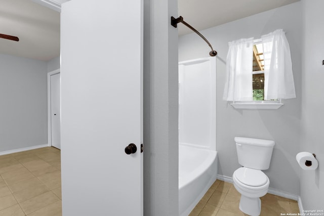 bathroom featuring bathtub / shower combination, toilet, tile patterned flooring, and baseboards