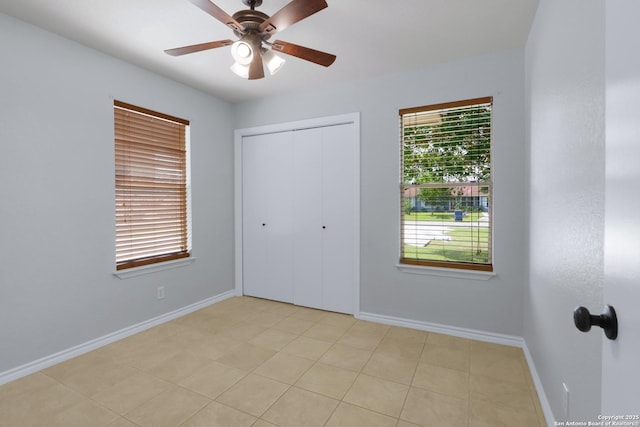 unfurnished bedroom featuring baseboards, a ceiling fan, and a closet
