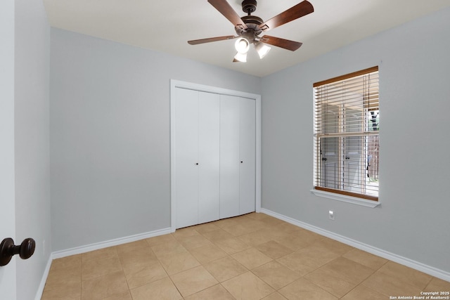 unfurnished bedroom with ceiling fan, a closet, and baseboards