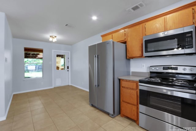 kitchen featuring appliances with stainless steel finishes, visible vents, light countertops, and baseboards
