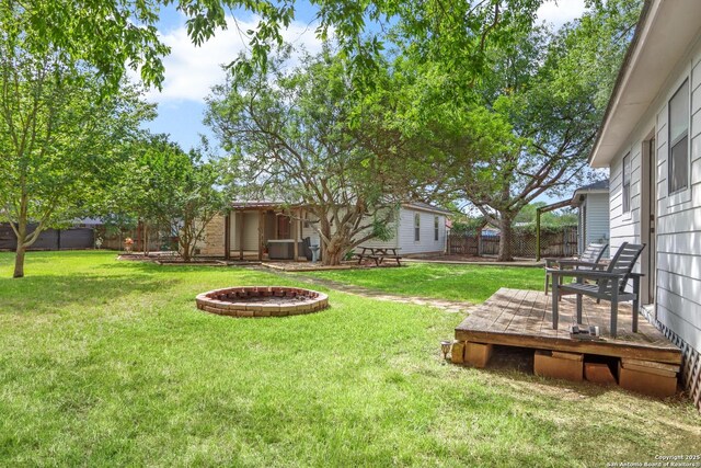 view of yard featuring an outdoor structure, a wooden deck, and a fenced backyard