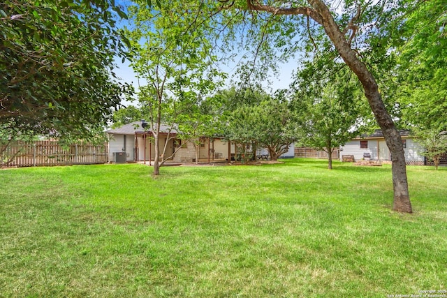 view of yard featuring fence and central air condition unit