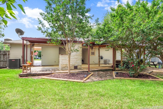 rear view of property featuring central AC, fence, a patio, and a lawn