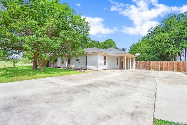 ranch-style home with fence, a carport, concrete driveway, and a front yard