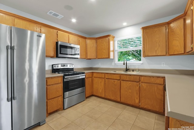 kitchen featuring a sink, light tile patterned floors, visible vents, light countertops, and appliances with stainless steel finishes