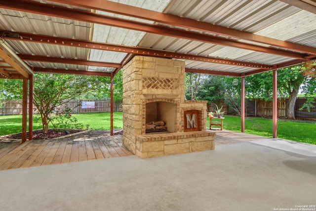 view of patio featuring a wooden deck, an outdoor stone fireplace, and a fenced backyard