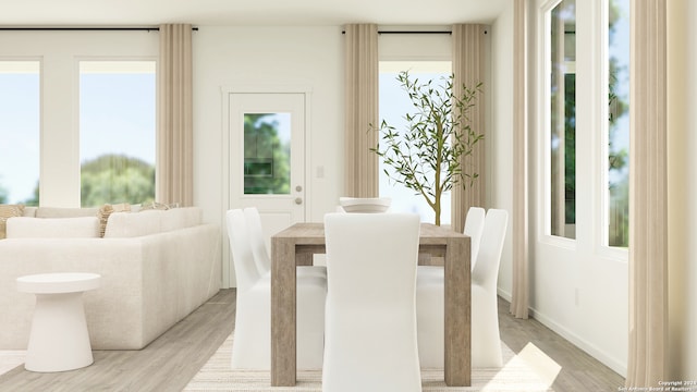 dining area featuring baseboards and light wood finished floors