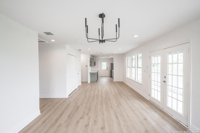 unfurnished living room featuring visible vents, a chandelier, light wood-type flooring, recessed lighting, and french doors