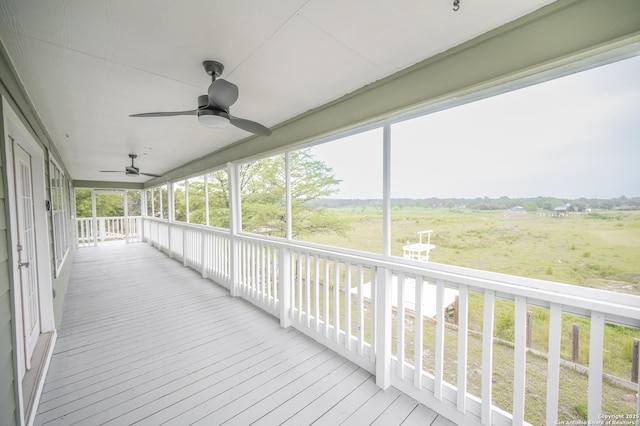 unfurnished sunroom with a ceiling fan