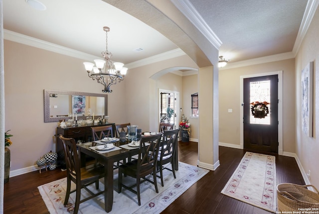 dining room with wood finished floors, plenty of natural light, a notable chandelier, and arched walkways