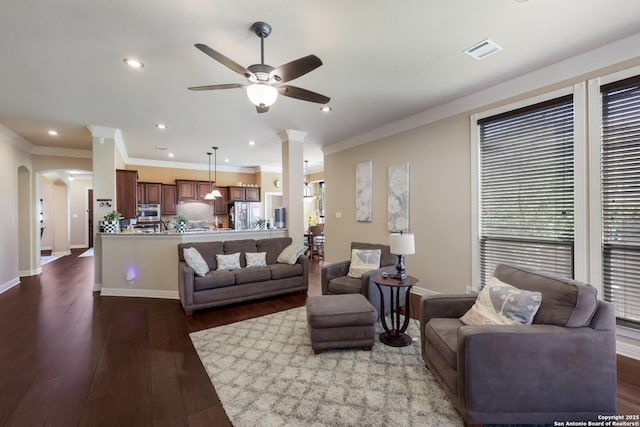 living area with crown molding, a ceiling fan, visible vents, and dark wood-type flooring