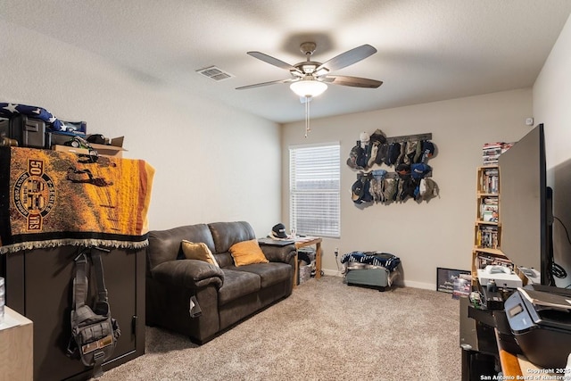 carpeted living area with baseboards, visible vents, and ceiling fan