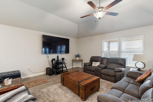 living area with lofted ceiling, ceiling fan, wood finished floors, and baseboards