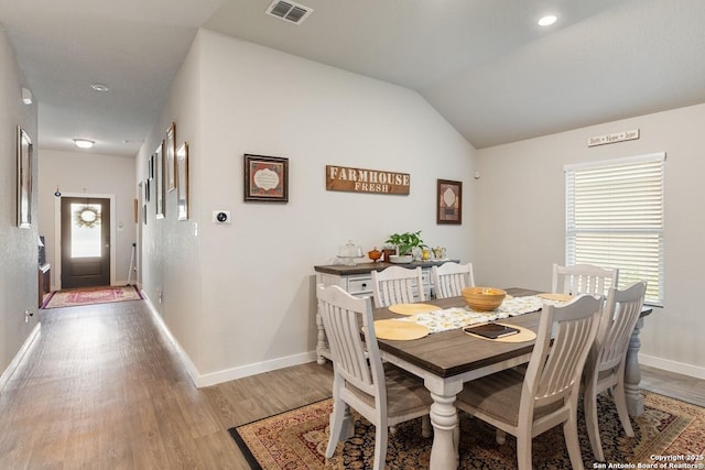 dining area featuring lofted ceiling, visible vents, light wood-type flooring, and baseboards