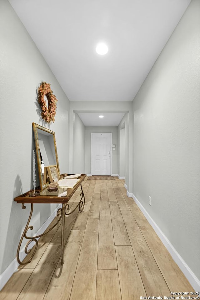 hallway with baseboards and light wood-type flooring