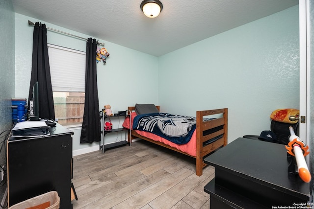 bedroom featuring a textured ceiling and light wood-type flooring