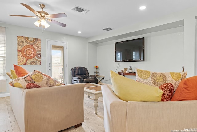 living area featuring light tile patterned flooring, visible vents, a ceiling fan, and recessed lighting