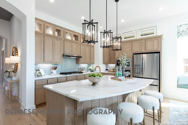 349 Hulda, New Braunfels, TX 78130 - kitchen featuring an inviting chandelier, decorative backsplash, a center island with sink, light wood-style flooring, and appliances with stainless steel finishes