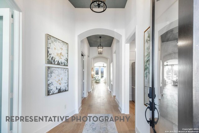 349 Hulda, New Braunfels, TX 78130 - hallway featuring french doors, baseboards, an inviting chandelier, arched walkways, and wood finished floors
