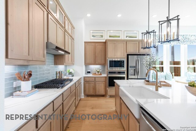 349 Hulda, New Braunfels, TX 78130 - kitchen with decorative backsplash, appliances with stainless steel finishes, under cabinet range hood, decorative light fixtures, and a notable chandelier
