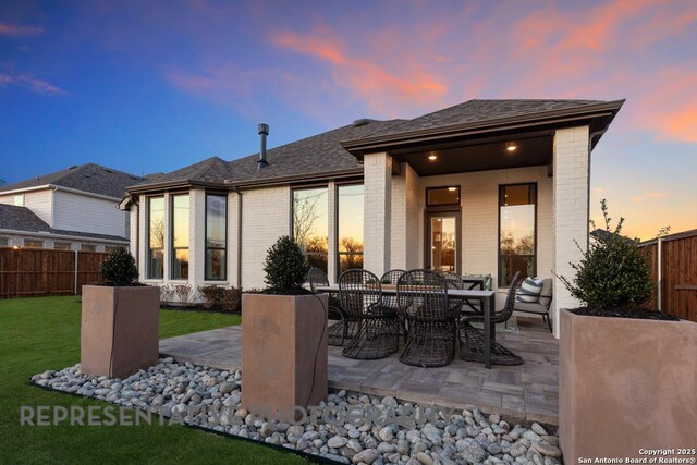 349 Hulda, New Braunfels, TX 78130 - back of property featuring a lawn, brick siding, a fenced backyard, and a patio area
