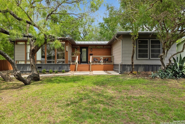 back of property with a lawn and a wooden deck