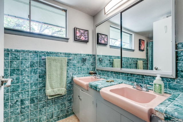 bathroom featuring a shower with shower curtain, tile walls, tile patterned floors, vanity, and wainscoting