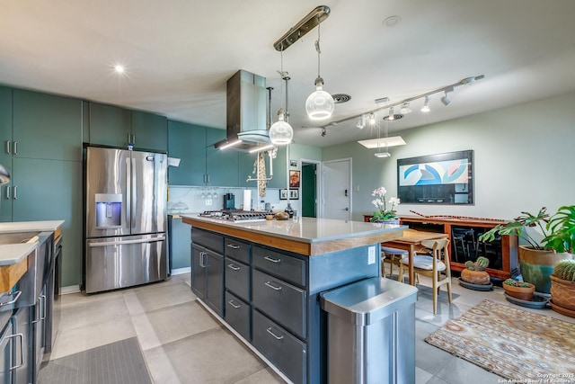 kitchen featuring hanging light fixtures, stainless steel appliances, extractor fan, a kitchen island, and light countertops