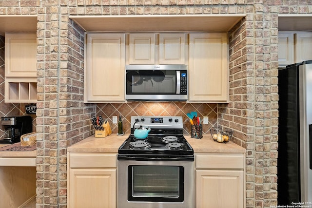 kitchen featuring appliances with stainless steel finishes, decorative backsplash, and light countertops