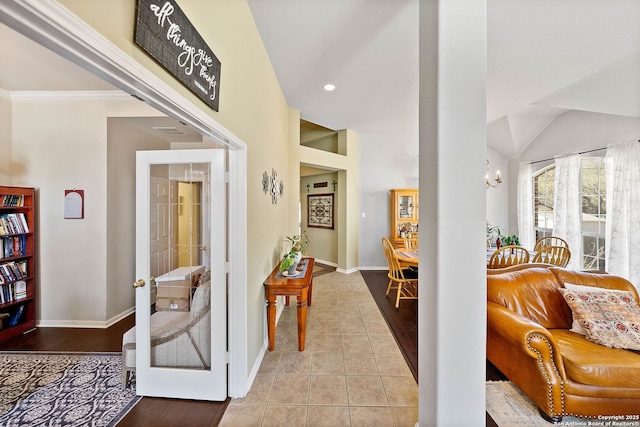 corridor featuring baseboards, ornamental molding, and tile patterned flooring