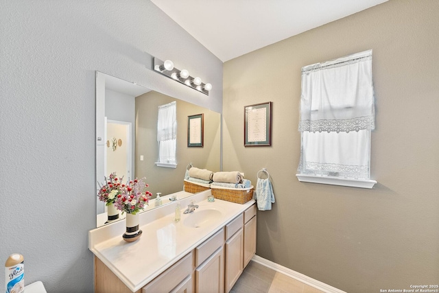 bathroom featuring tile patterned flooring, vanity, and baseboards