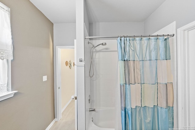 full bathroom featuring shower / bath combination with curtain and baseboards