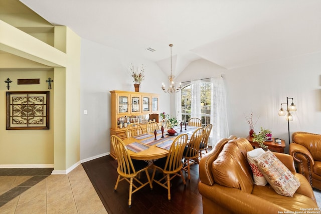 dining area with a chandelier, visible vents, baseboards, vaulted ceiling, and tile patterned flooring