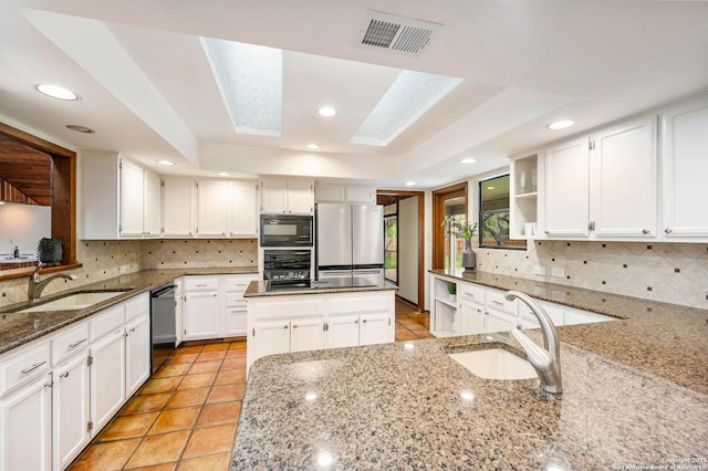 kitchen with open shelves, visible vents, a sink, and black appliances