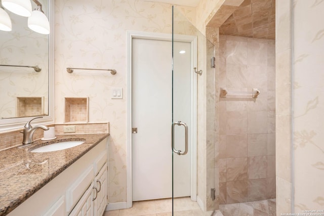 full bathroom with vanity, a stall shower, and wallpapered walls