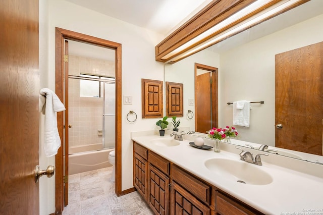 full bathroom featuring a sink, bathtub / shower combination, toilet, and double vanity